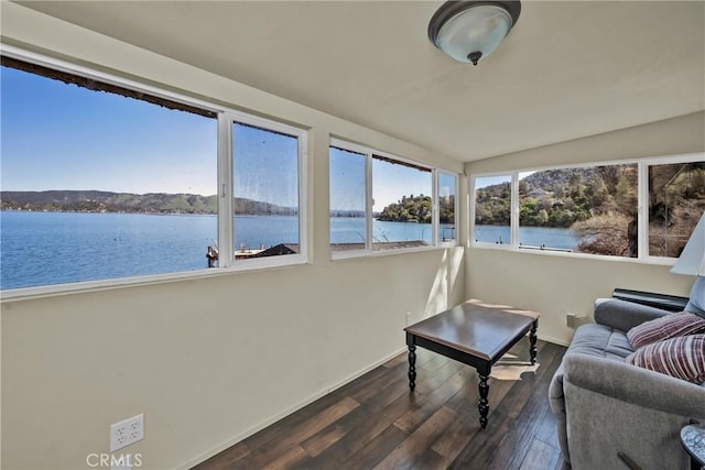 sunroom featuring a water view