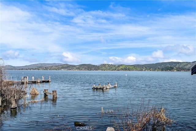 property view of water with a mountain view and a boat dock