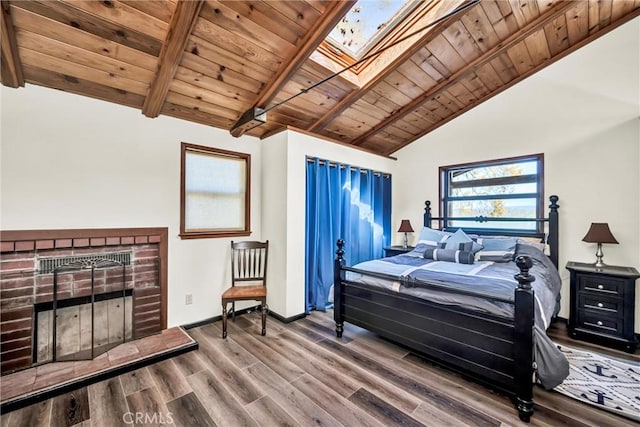 bedroom with wood finished floors, baseboards, wood ceiling, lofted ceiling with skylight, and a brick fireplace