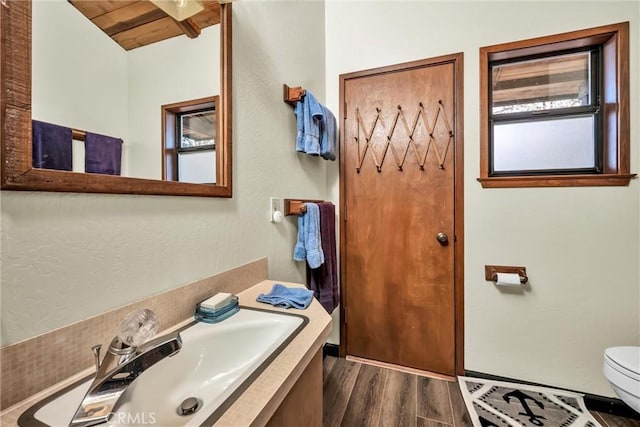 bathroom with wood ceiling, toilet, vanity, and wood finished floors