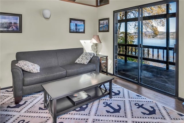 living room with wood finished floors, a water view, and baseboards