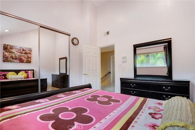 bedroom with visible vents, a closet, and high vaulted ceiling