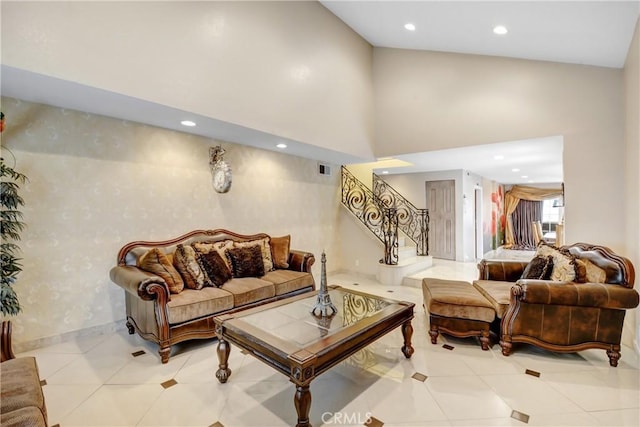 tiled living room featuring visible vents, baseboards, stairway, recessed lighting, and a towering ceiling