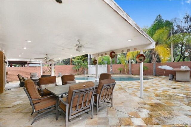 view of patio / terrace with a fenced in pool, a fenced backyard, a ceiling fan, and outdoor dining space