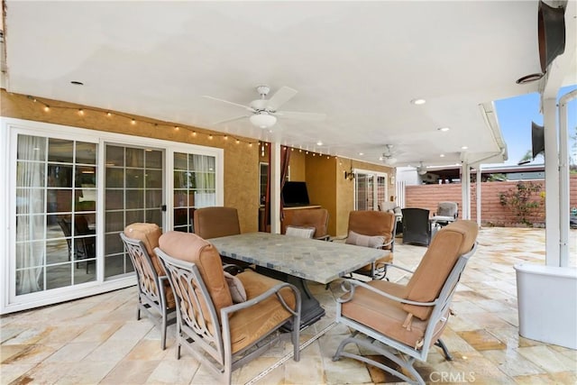 view of patio / terrace featuring outdoor dining space, fence, and ceiling fan