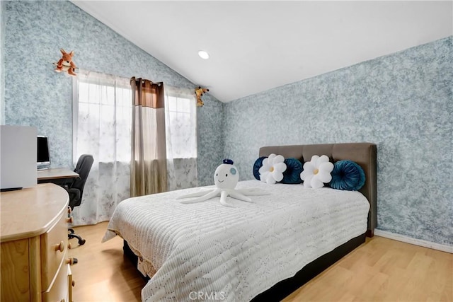 bedroom with wallpapered walls, vaulted ceiling, recessed lighting, and wood finished floors