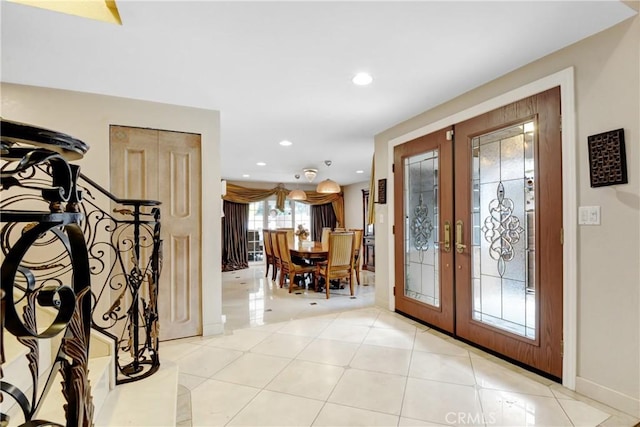 foyer entrance with light tile patterned floors, recessed lighting, french doors, and baseboards