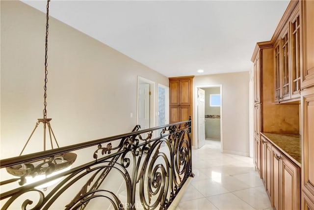 corridor featuring recessed lighting, baseboards, and light tile patterned flooring