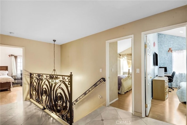 corridor with baseboards and light tile patterned flooring