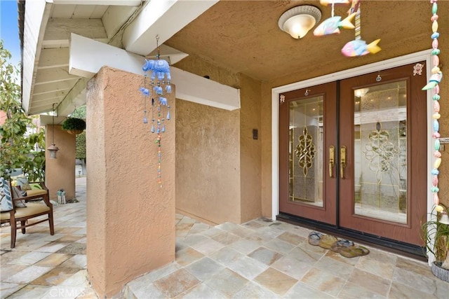 doorway to property featuring french doors and stucco siding