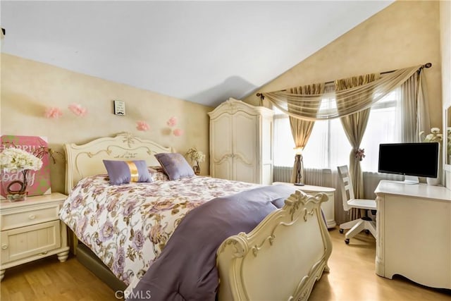 bedroom with lofted ceiling and light wood-type flooring