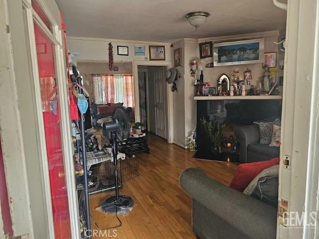 living area with crown molding and wood finished floors