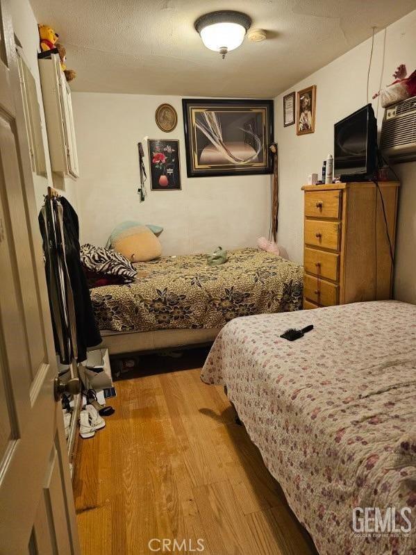 bedroom featuring a textured ceiling and wood finished floors