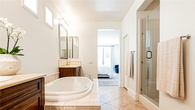 ensuite bathroom featuring vanity, tile patterned flooring, a shower stall, a garden tub, and connected bathroom