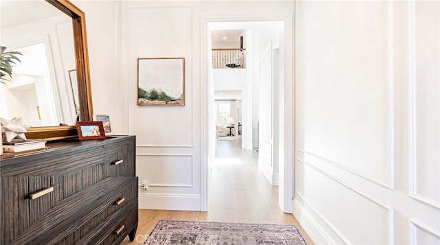 hallway featuring a decorative wall and light wood-style floors