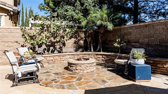 view of patio with an outdoor fire pit and a fenced backyard