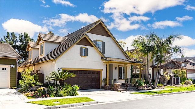 view of front of home featuring stucco siding, a chimney, driveway, and a tile roof