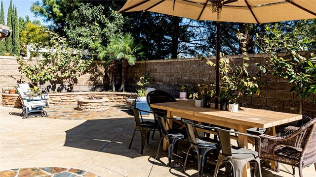 view of patio featuring outdoor dining area, a fire pit, and a fenced backyard