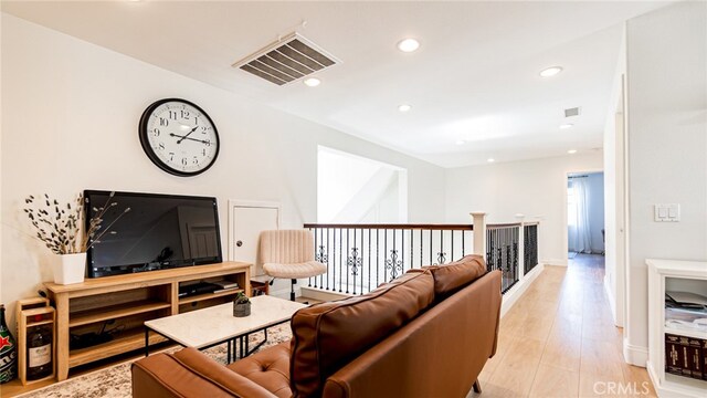 living area featuring recessed lighting, light wood-style floors, and visible vents