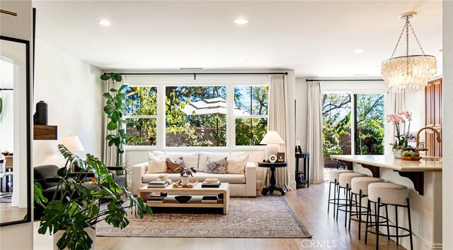 living area featuring recessed lighting, an inviting chandelier, and wood finished floors