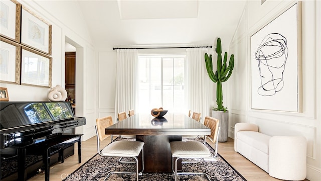 dining space featuring a wealth of natural light, a decorative wall, and light wood-type flooring