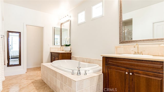 full bath with decorative backsplash, two vanities, a garden tub, and a sink