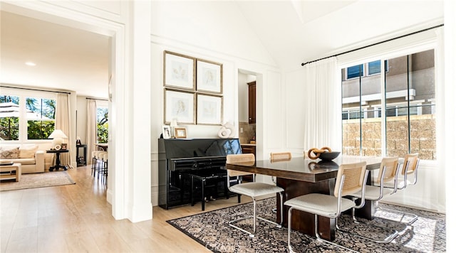 dining space with vaulted ceiling and wood finished floors