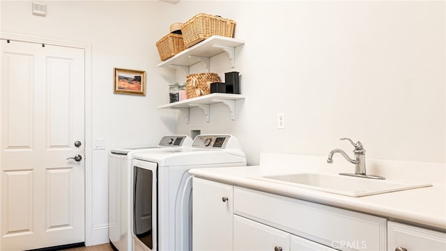 washroom featuring washer and dryer, cabinet space, and a sink