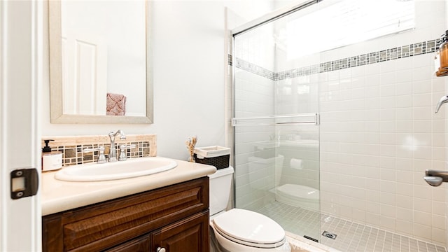 full bath with tasteful backsplash, toilet, vanity, and a stall shower