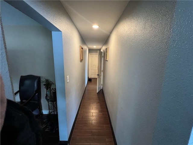 hall with baseboards, dark wood-style flooring, and a textured wall