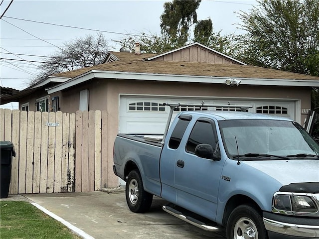 view of property exterior with roof with shingles, a garage, and fence