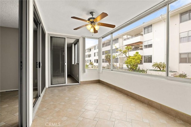 unfurnished sunroom with ceiling fan