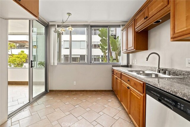 kitchen with dishwasher, baseboards, brown cabinets, and a sink