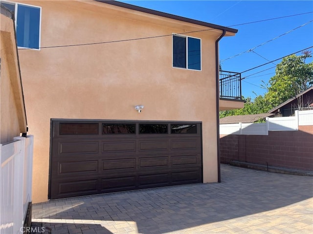 garage featuring driveway and fence