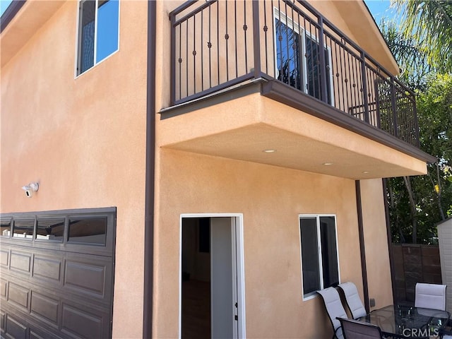 back of property with stucco siding and a balcony