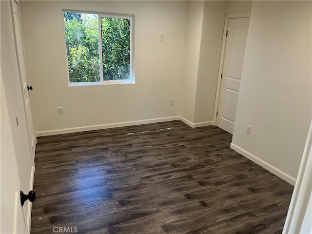 unfurnished bedroom with dark wood-style floors and baseboards