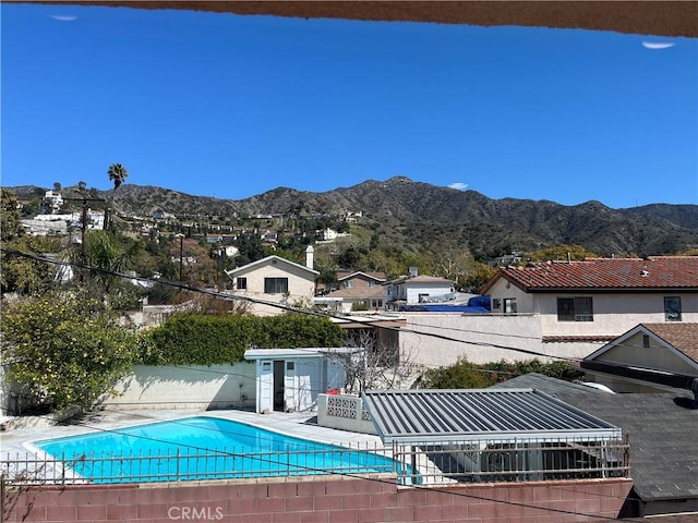 view of swimming pool with fence, a fenced in pool, and a mountain view