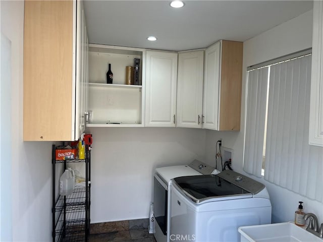 washroom featuring cabinet space, recessed lighting, separate washer and dryer, and a sink