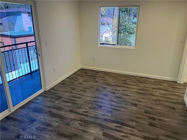 empty room featuring dark wood-style floors and baseboards