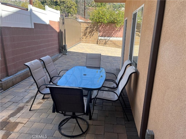 view of patio / terrace with outdoor dining space, a gate, and a fenced backyard