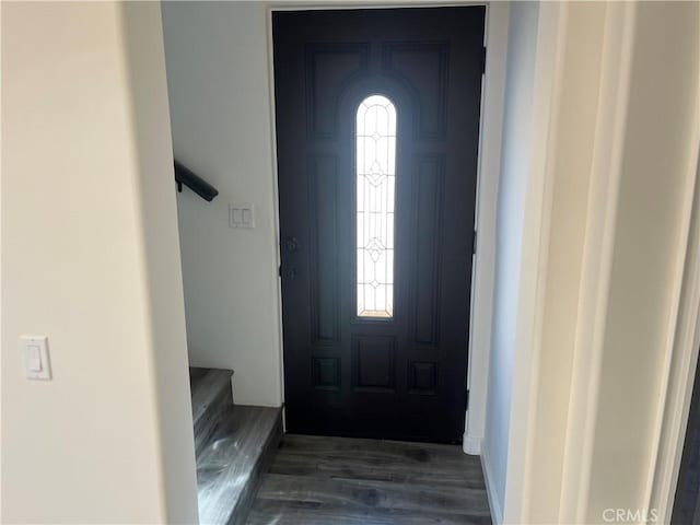 entrance foyer featuring a healthy amount of sunlight, dark wood-style floors, and stairs