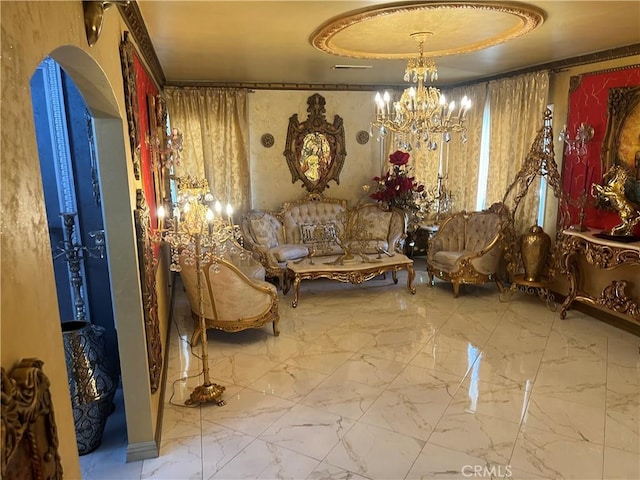 sitting room featuring a tray ceiling, a notable chandelier, and marble finish floor