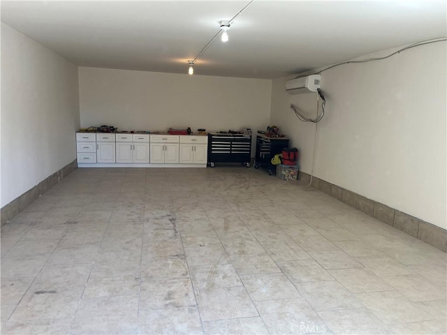 garage featuring an AC wall unit and baseboards