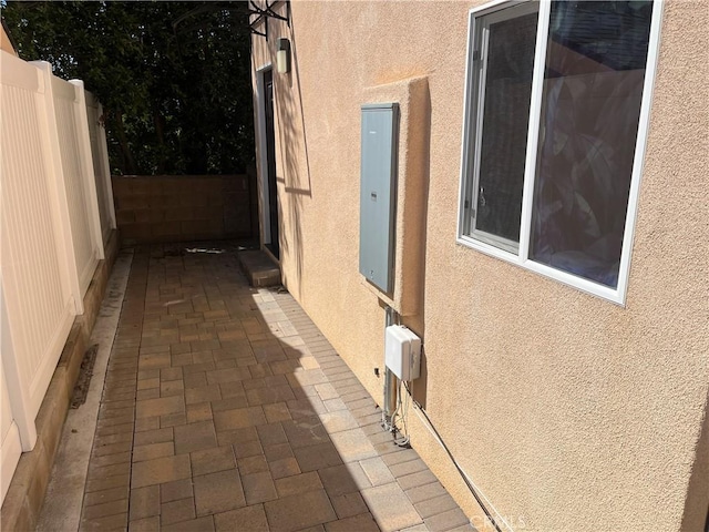 view of side of property featuring fence and stucco siding