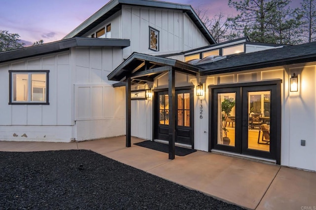 exterior entry at dusk with french doors and board and batten siding