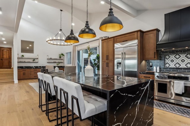 kitchen featuring decorative backsplash, light wood-style flooring, premium range hood, and stainless steel appliances