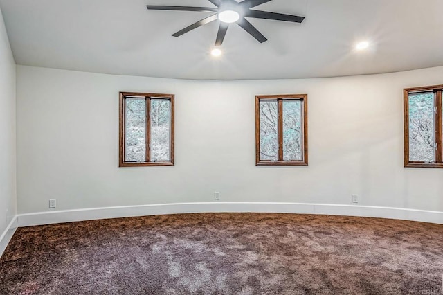 carpeted empty room featuring a ceiling fan, baseboards, and a healthy amount of sunlight