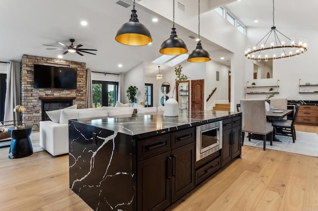 kitchen with stainless steel microwave, visible vents, and open floor plan