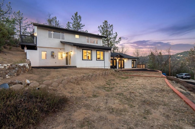 rear view of property featuring stucco siding