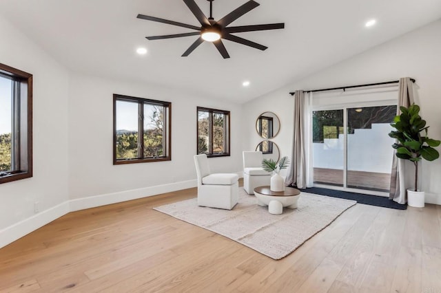 living area with baseboards, lofted ceiling, ceiling fan, and wood finished floors